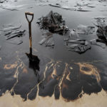 TOPSHOTSA shovel sits in oil-covered sa