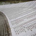 Fadila Efendic prays near memorial plaques at the Potocari genocide memorial centre near Srebrenica