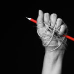 Hand,With,Red,Pencil,Tied,With,Rope,,Depicting,The,Idea